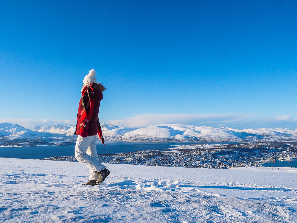 Alleinreisende in der Winterlandschaft auf dem Berg Storsteinen in Tromsö in Norwegen