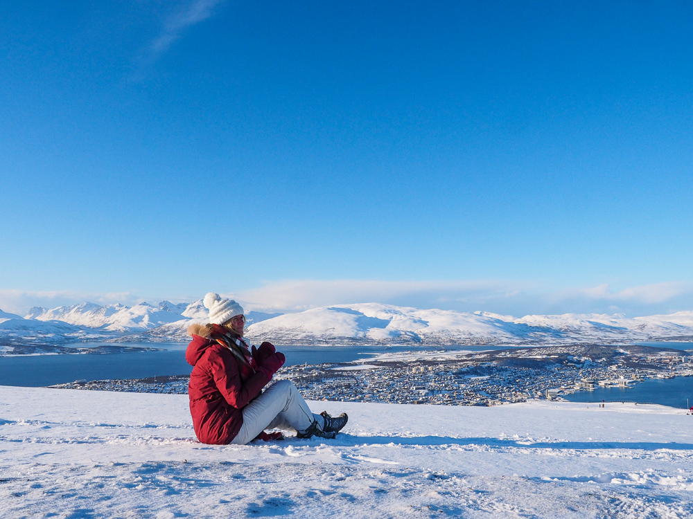 Alleinreisende in Winterlandschaft auf dem Berg Storsteinen in Tromsö in Norwegen