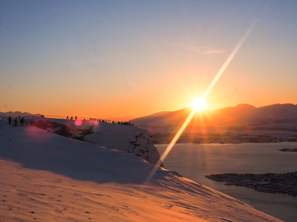 Winterpanorama Tromso vom Hausberg Storsteinen mit verschneiter Landschaft zum Sonnenuntergang 