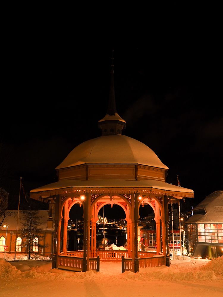 Beleuchtetes Pavillion in Tromsö im Schnee während eines entspannten Spaziergangs abends durch die Stadt