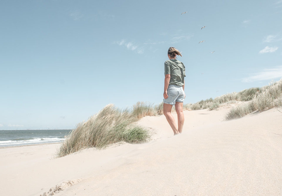 Alleinreisende Frau genießt die Ruhe am Strand und in den Dünen in Holland – Slow Travel an der Nordsee