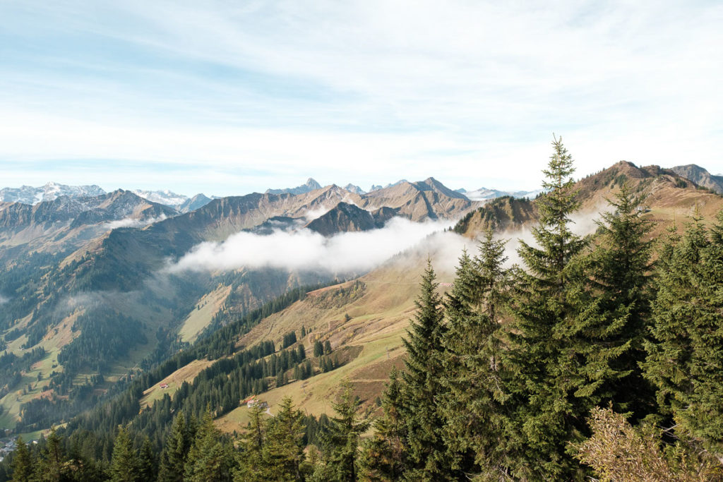 Aussicht vom Walmendingerhorn im herbstlichen Kleinwalsertal auf das Bergpanorama bei Sonne und Nebel.