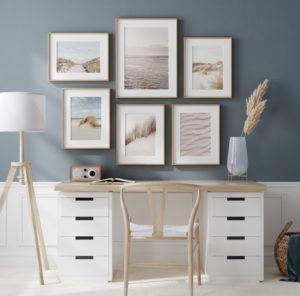 Große Bilderwand über Schreibstisch im Homeoffice mit sechs harmonischen Postern in Blau- und Beigetönen