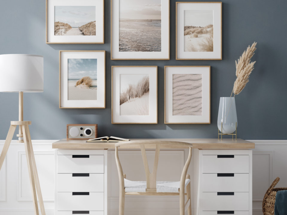 Große Bilderwand über Schreibstisch im Homeoffice mit sechs harmonischen Postern in Blau- und Beigetönen