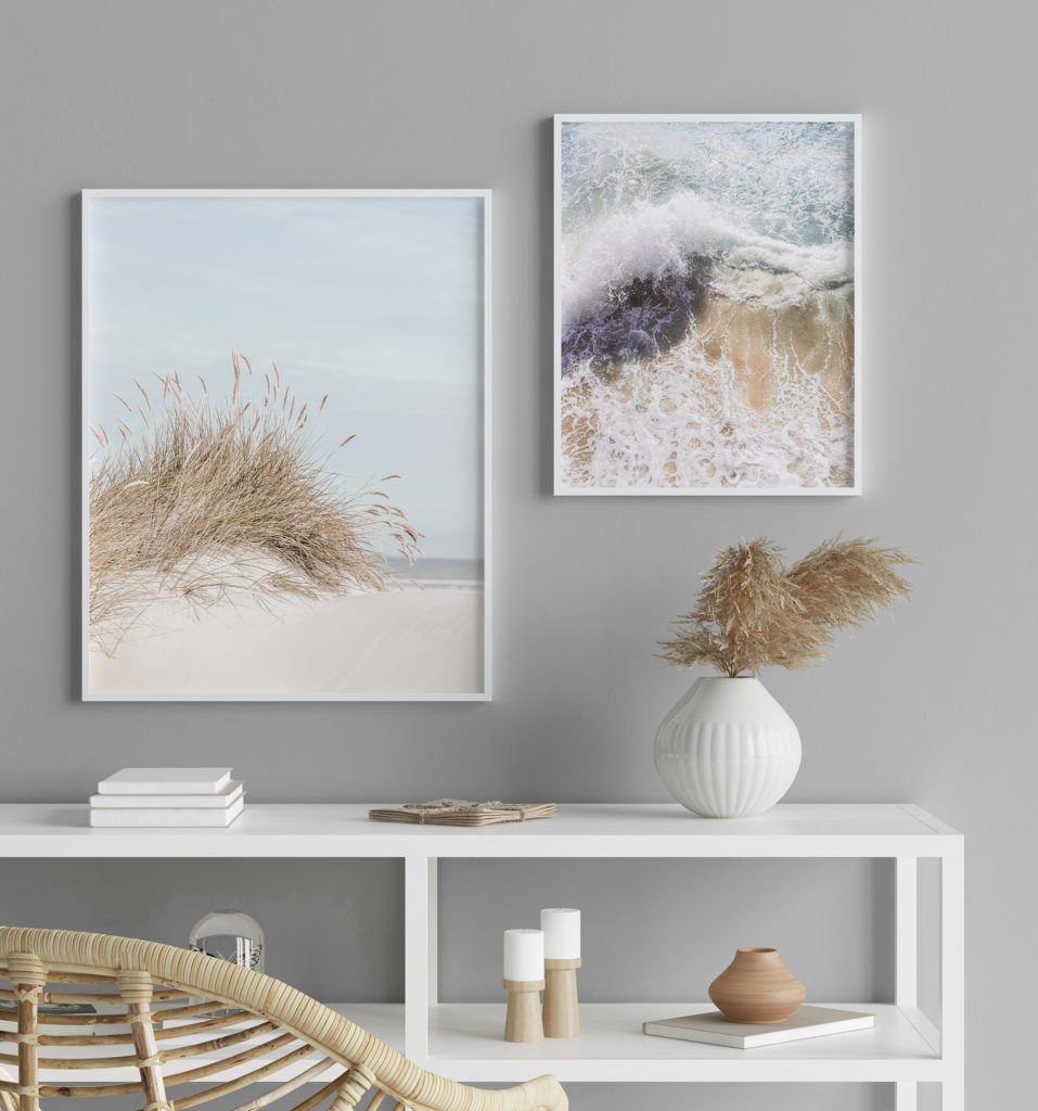 Zwei Poster nebeneinander im Flur, ruhige Farben und weiße Holzrahmen