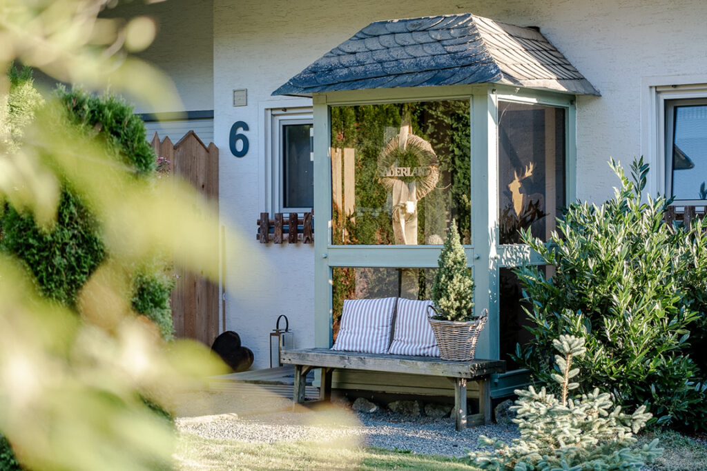 Hauseingang mit Sitzbank und bepflanztem Garten im Haus am Wald in Olsberg