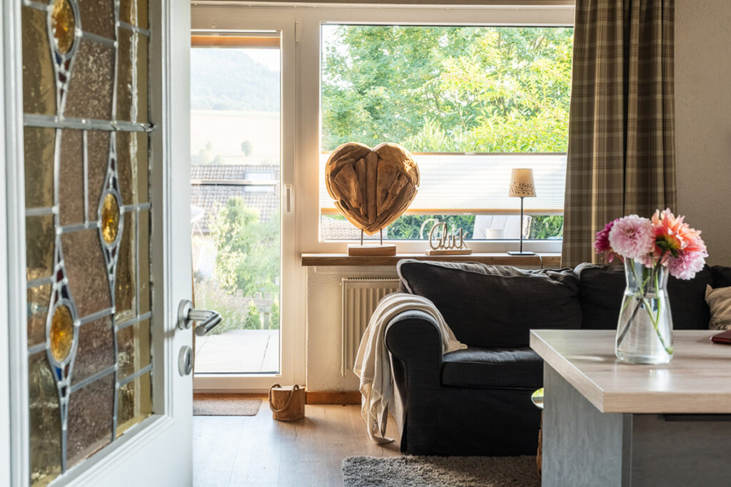 Blick auf das Fenster mit Dekoration und Blumen im gemütlichen Wohnbereich